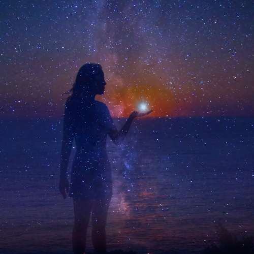 the silhouette of a woman infront of the night sky with her hand stretched holding a star