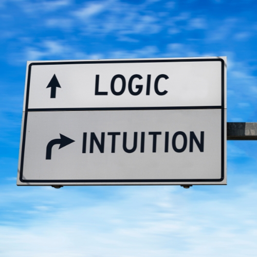 a road sign with ahead pointing to logic and right pointing to intuition